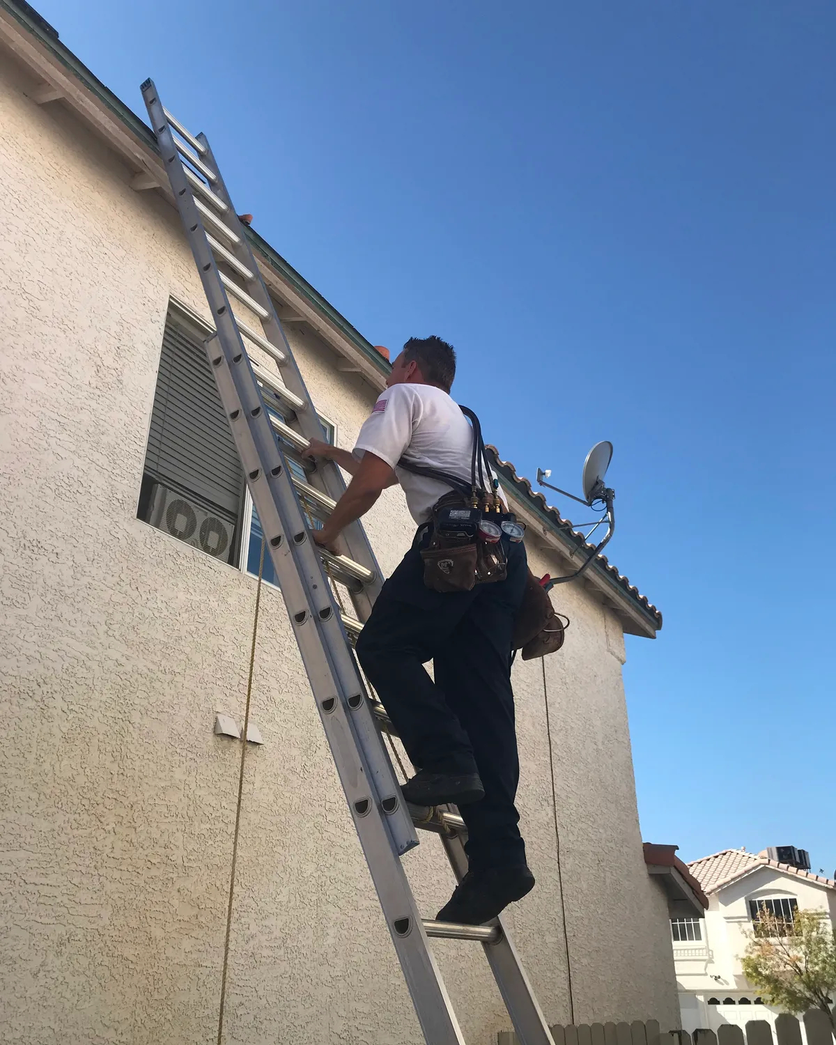 HVAC technician climbing ladder for installation